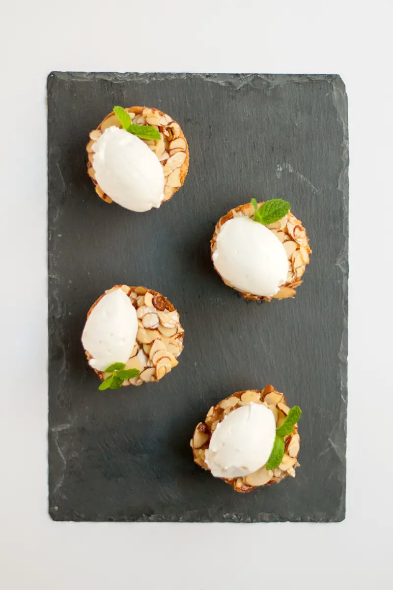 A cute almond tart made in a muffin tin. Tart crust, almond filling, and a glazed almond topping. Top with whipped cream for an elegant dessert.