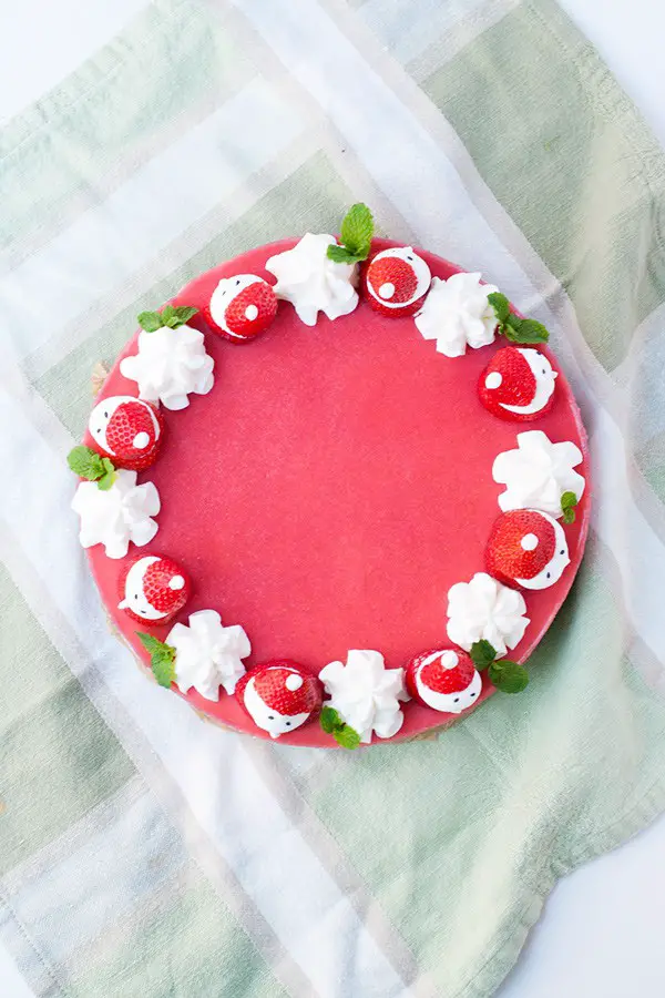 Strawberry mousse cake topped with strawberry santas.