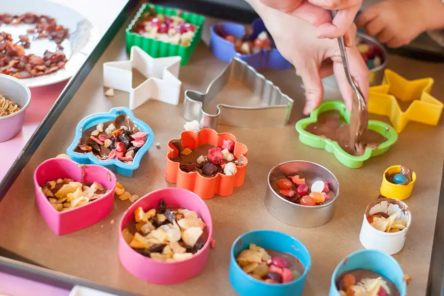 Cookie Cutter candy chocolate recipe: These cookie cutter chocolates are a great activity to do with kids! Melted chocolate is poured into cookie cutter molds and topped with all sorts of fun toppings!