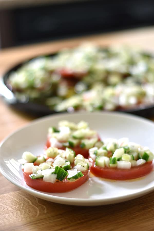Sliced Tomato Salad with Cucumber Onion Marinade- Sliced tomatoes topped with a chopped cucumbers and onion in a tangy marinade. This sliced tomato salad is so fresh and comes together in a snap. 