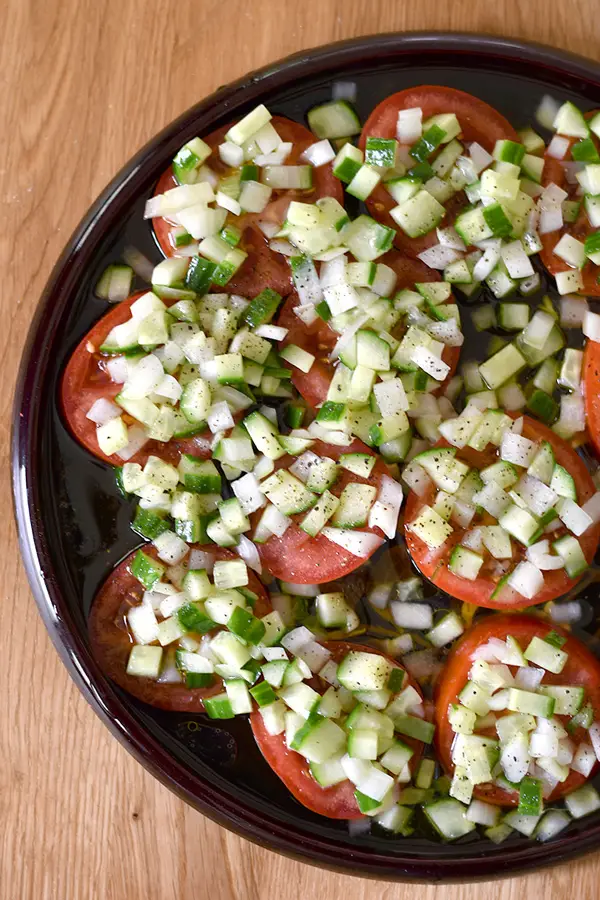 Sliced Tomato Salad with Cucumber Onion Marinade- Sliced tomatoes topped with a chopped cucumbers and onion in a tangy marinade. This sliced tomato salad is so fresh and comes together in a snap. 