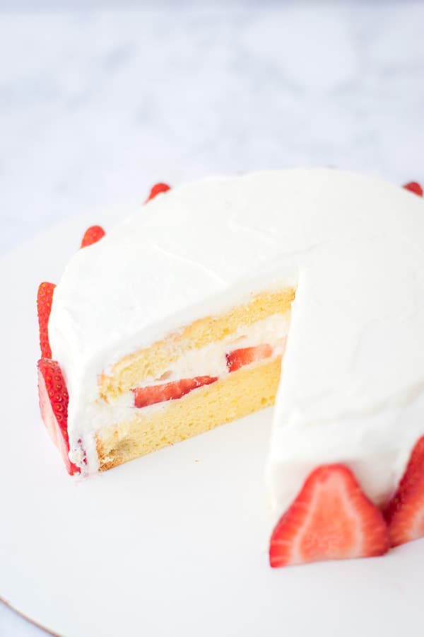Japanese strawberry shortcake with a slice cut out of it. 