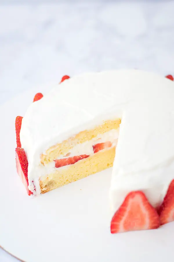 Japanese strawberry shortcake with a slice cut out of it. 