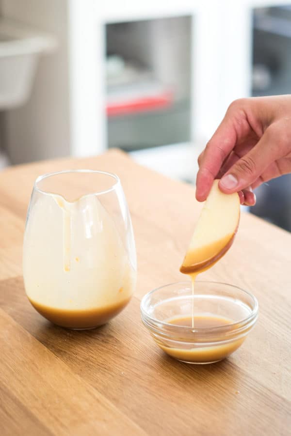 Dipping an apple slice into a bowl of miso butterscotch.