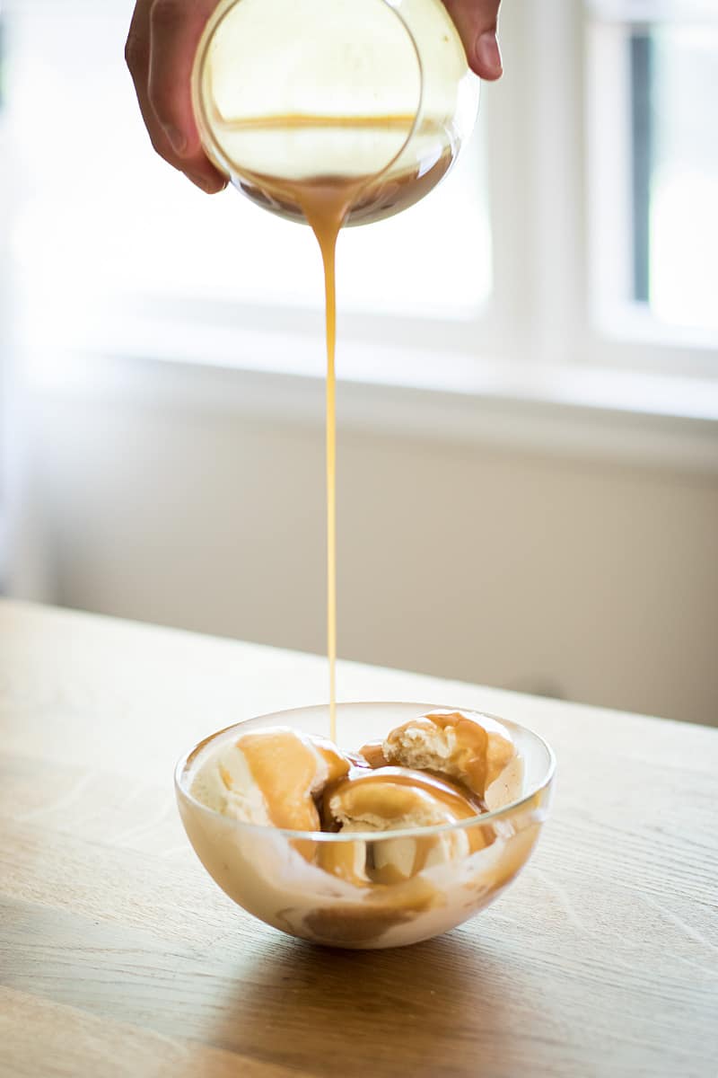 drizzling miso butterscotch onto a bowl of vanilla ice cream. 