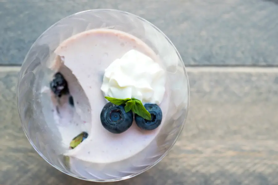 Top view of blueberry no bake yogurt cheesecake cup with bite taken out of it. 