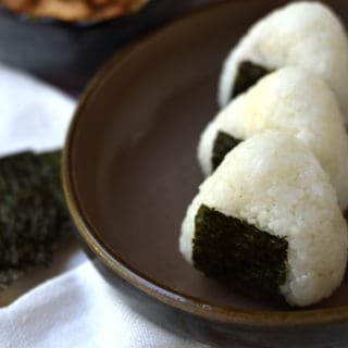 Tuna mayo onigiri, or rice ball, is a simple and delicious Japanese snack. Rice is filled with a flavorful tuna and mayonnaise, shaped, and wrapped with a sheet of nori (seaweed).