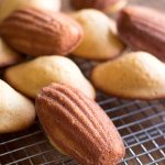 Freshly baked French madeleines cooling on rack.