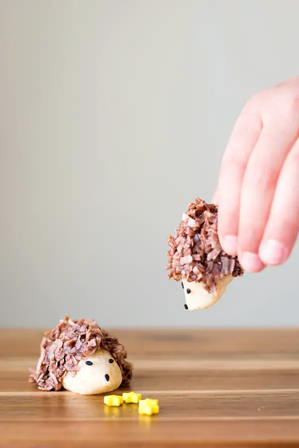 Two hedgehog cookies eating star sprinkles.