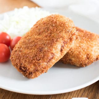 Korokke, or Japanese potato croquettes, served with cherry tomatoes and shredded cabbage.