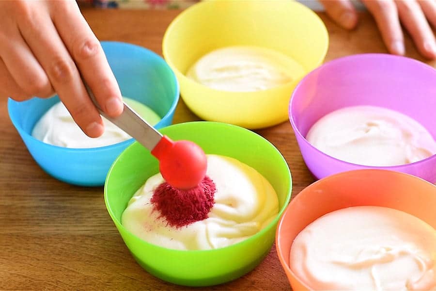 Mixing crushed freeze dried raspberries into yogurt. Japanese rare cheesecake uses yogurt for a more tart and less sweet taste.