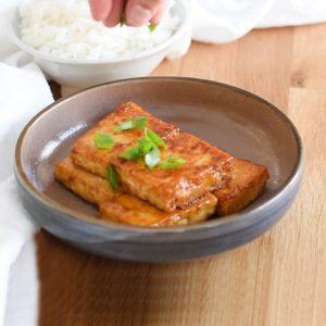 tofu steak with butter glaze garnished with green oinions.